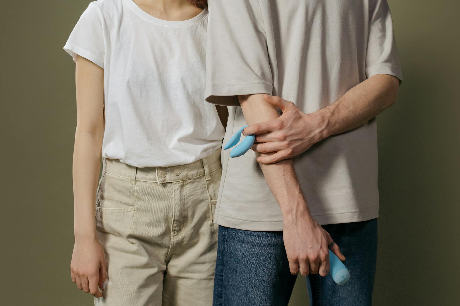 A couple holding a blue vibrator together, representing shared intimacy and communication after ED diagnosis.
