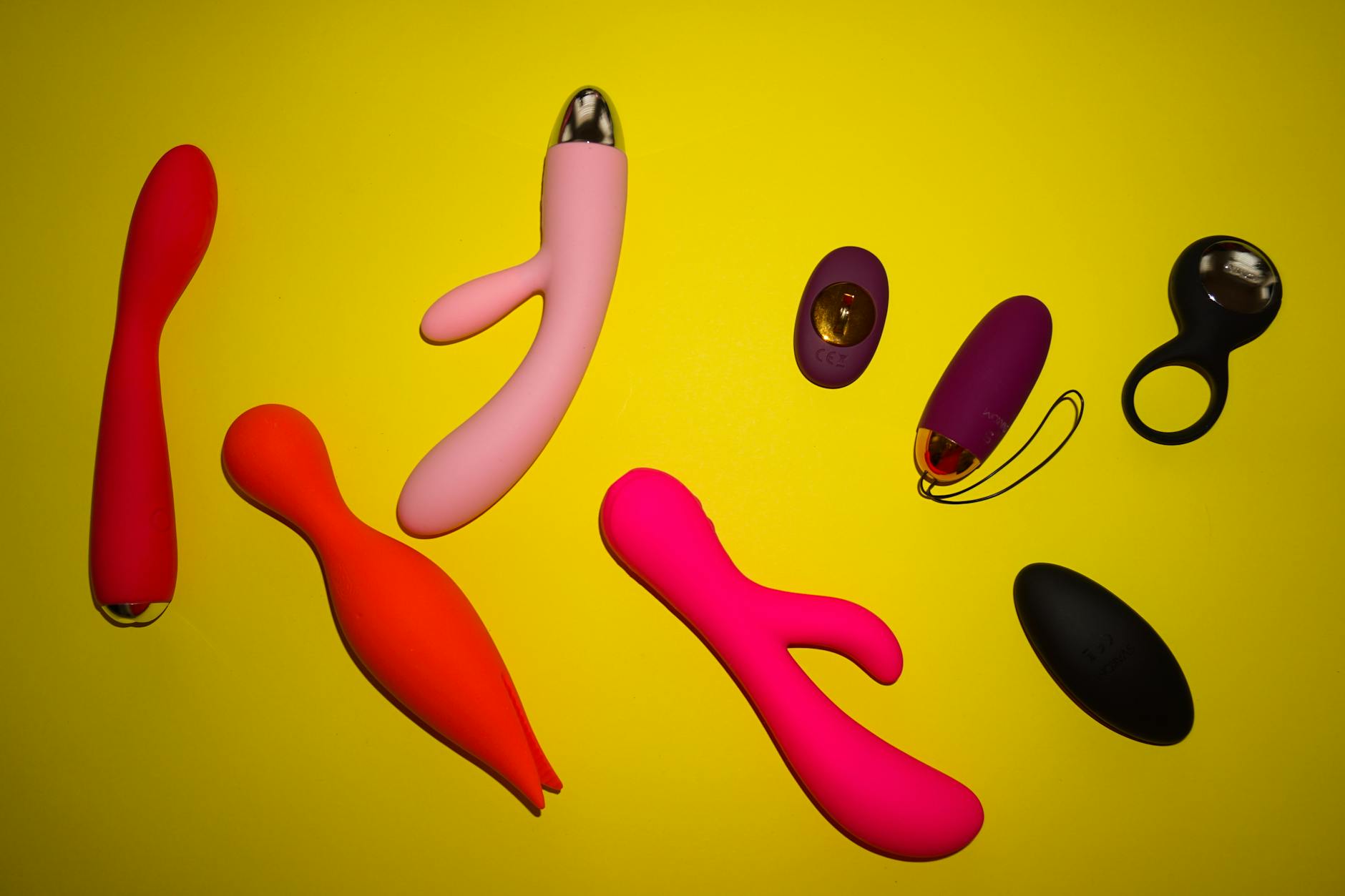 Hand holding a blue silicone vibrator against purple background, promoting self-love and sexuality